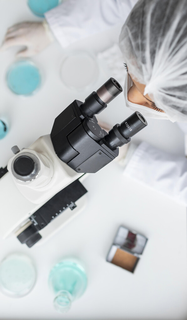 close up scientist looking through ocular lens LR